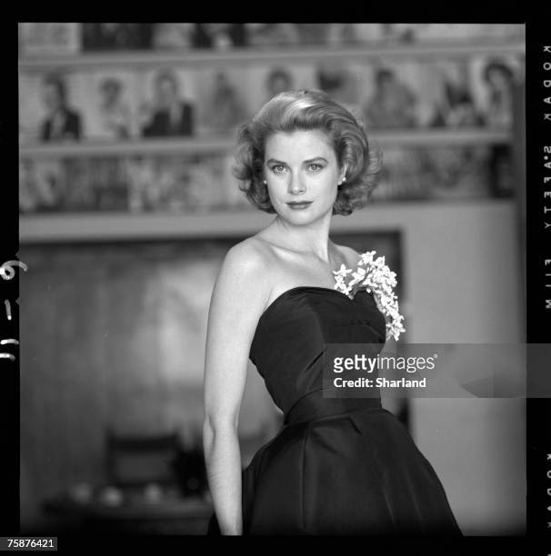 Portrait of American actress Grace Kelly in a strapless gown with a sprig of flowers tucked into her bodice, Hollywood, California, March 1954.