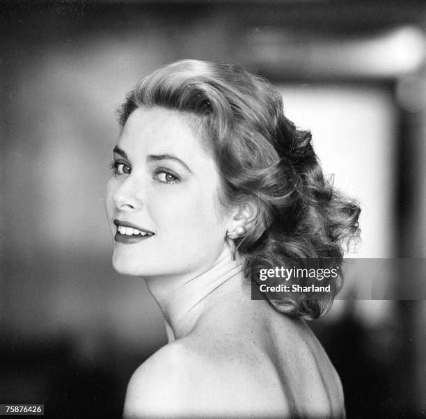 American actress Grace Kelly in a strapless gown as she looks over her shoulder, Hollywood, California, March 1954. The following April, Kelly...