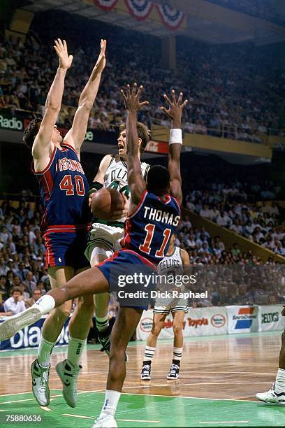 Danny Ainge of the Boston Celtics drives to the basket against Isiah Thomas and Bill Lambier of the Detroit Pistons during an NBA game circa...