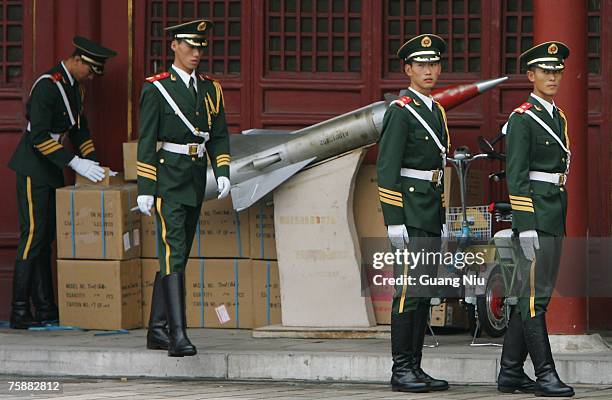 Chinese armed policemen stand next to a model of missile during a gift ceremony to mark the 80th anniversary of the founding of the People's...