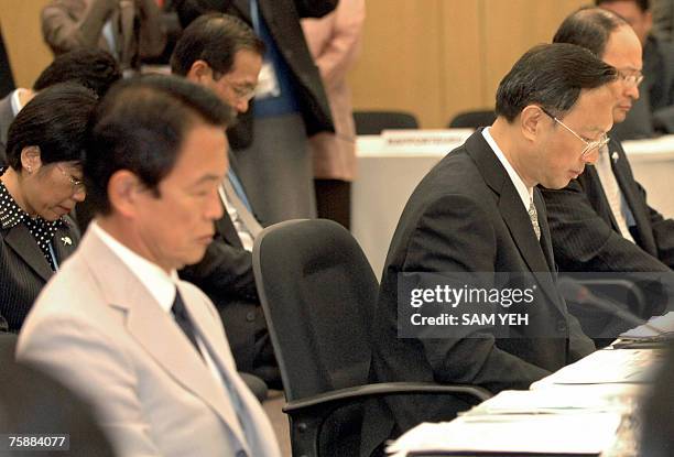 Japan Foreign Minister Taro Aso with his Chinese counterpart Yang Jiechi and South Korean foreign ministry representative Shim Yoon-Joe bows during a...