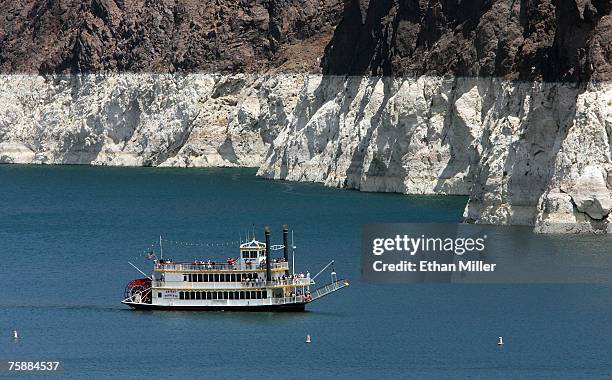 Tourists ride a paddleboat on Lake Mead on the upstream side of the Hoover Dam July 30, 2007 in the Lake Mead National Recreation Area, Nevada. The...