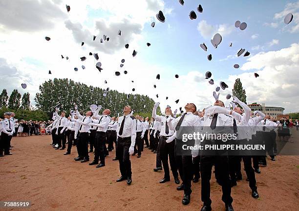 French police officer students throw their hats into the air while celebrating the end of their cursus 31 July 2007 at the Nationale Police...