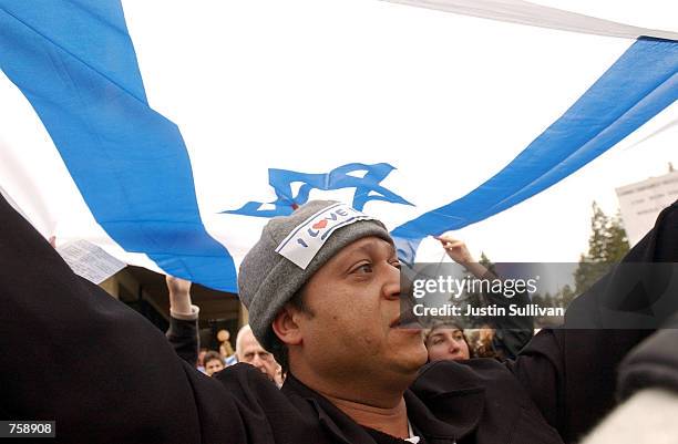 Pro-Israeli demonstrator carries the Israeli flag over his head April 9, 2002 during a demonstration on the University of California at Berkeley...