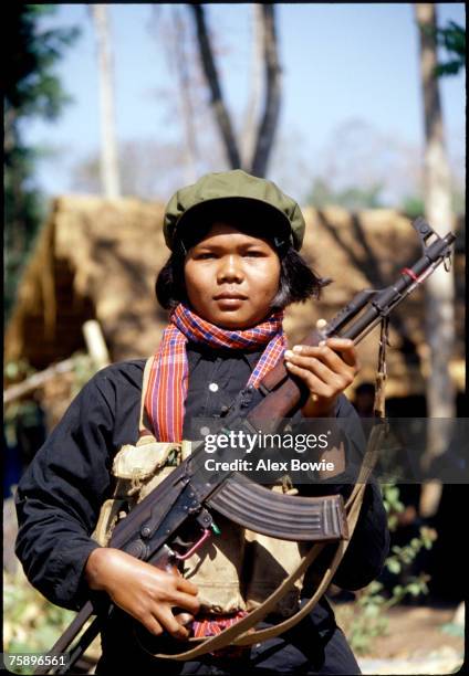 Female Khmer Rouge fighter or 'mit naree' carries an AK-47 assault rifle in the jungle of western Cambodia, 15th February 1981.