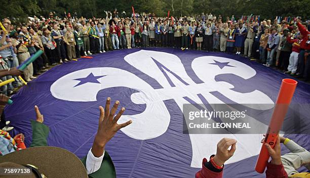 Scouts gather around a parachute marked with the Scouts emblem during a special ceremony on Brownsea Island off the south coast of England, 01 August...