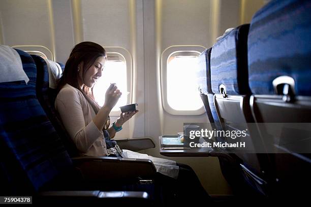 woman eating meal in airplane - airplane food stock-fotos und bilder