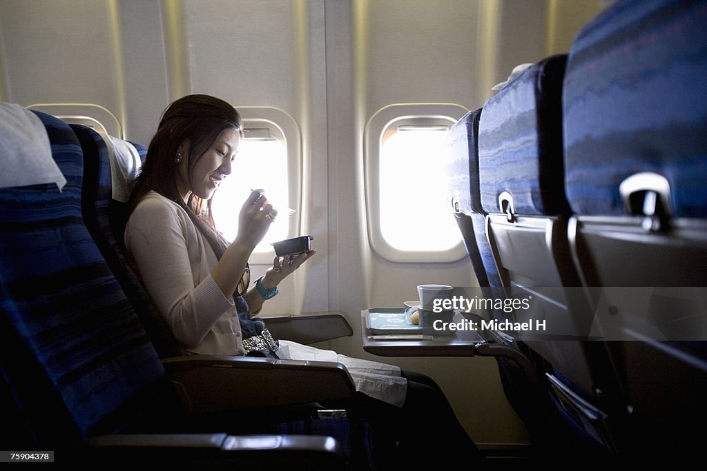 Woman eating meal in airplane