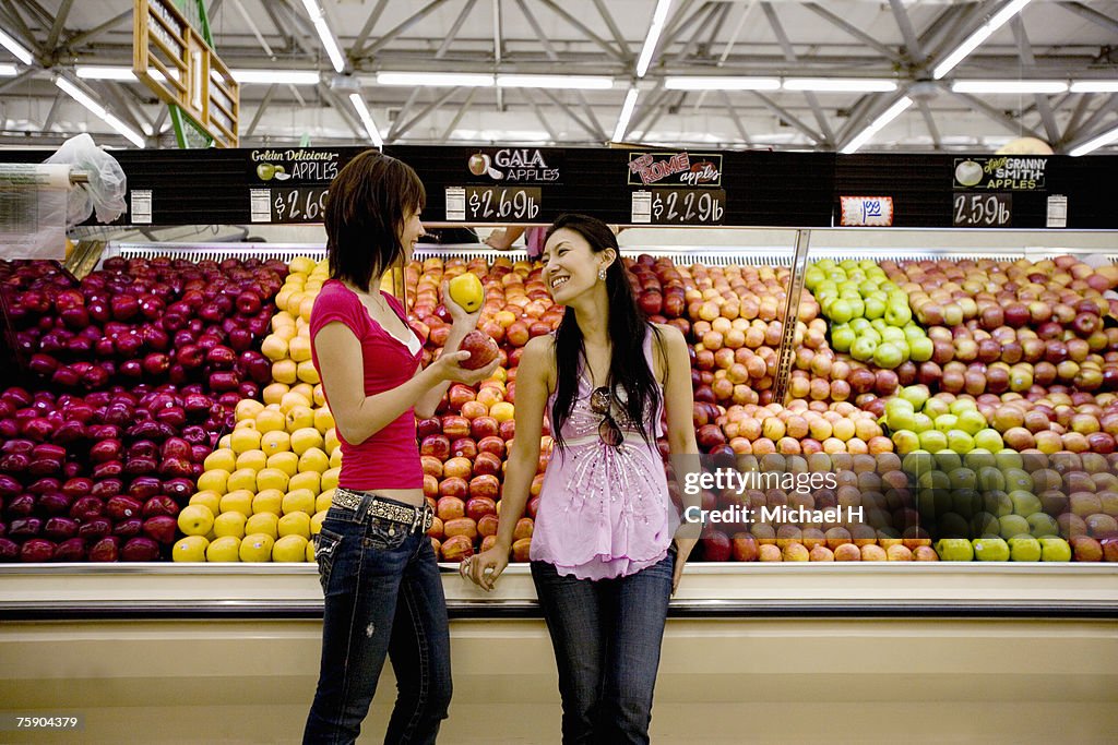 Two women in fruit market, smiling