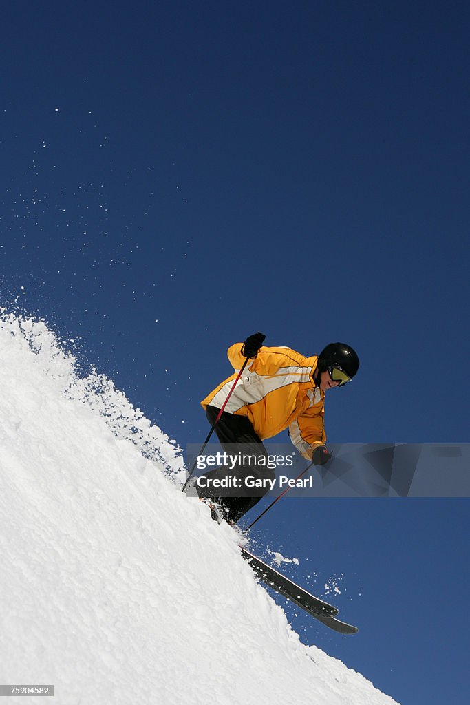 Male skier descending slope, side view