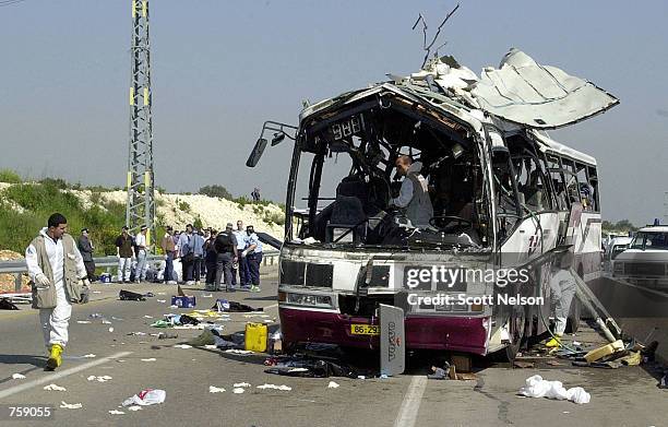 Israeli investigators examine the site of a Palestinian suicide bus bombing that killed at least eight people April 10, 2002 outside the Northern...