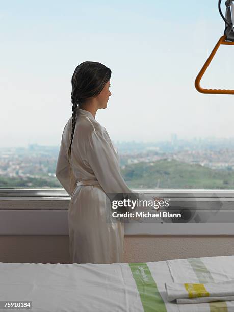 woman in robe looking out of window - 2007 243 stock pictures, royalty-free photos & images