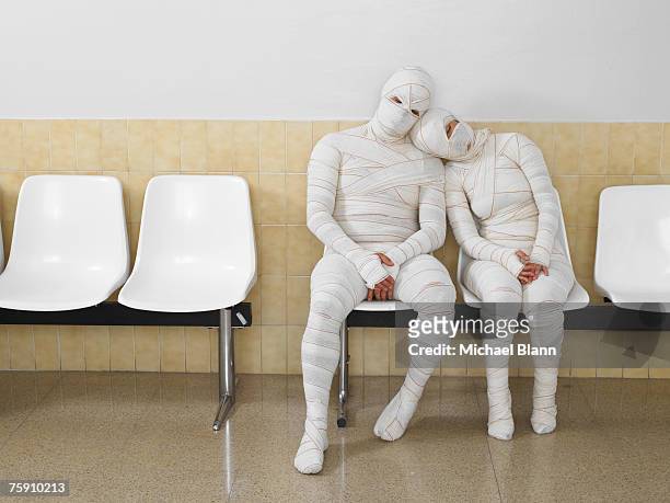 couple wrapped in bandages leaning together - fasciatura foto e immagini stock