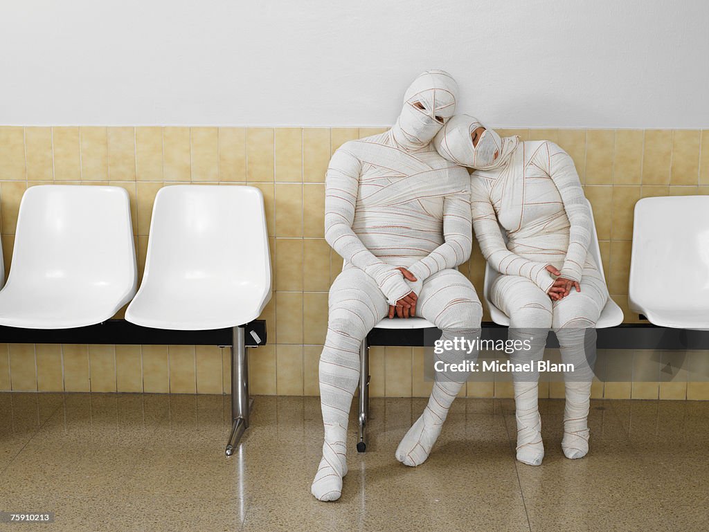 Couple wrapped in bandages leaning together