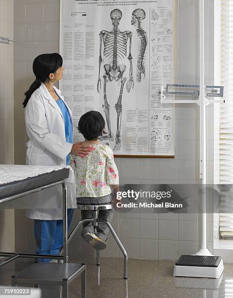 doctor showing girl (5-7 years) poster in examination room - child having medical bones stock pictures, royalty-free photos & images