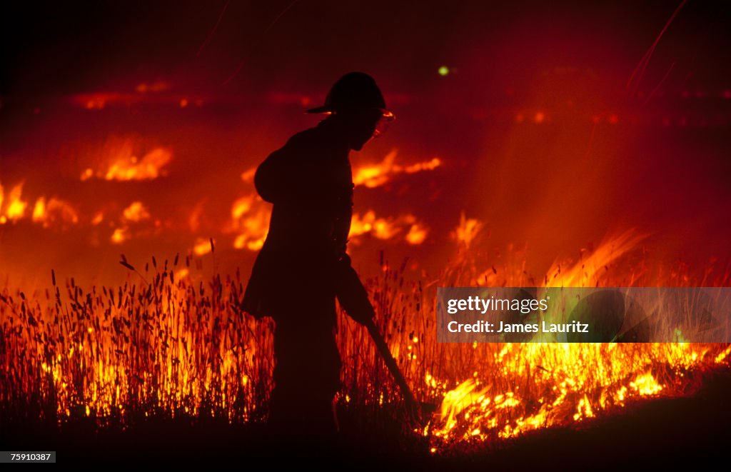 Firefighter attending grass fire