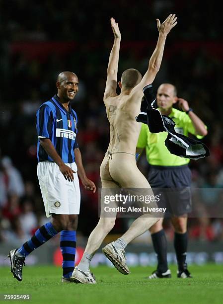 Olivier Dacourt of Inter Milan smiles as a streaker runs across the pitch during the pre-season friendly match between Manchester United and Inter...