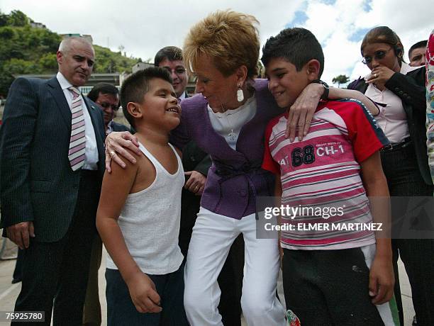 La vicepresidenta de Espa?a, Mar?a Teresa Fern?ndez de la Vega, abraza a dos ni?os durante una visita a la escuela Daniel Casco en la colonia Buenas...