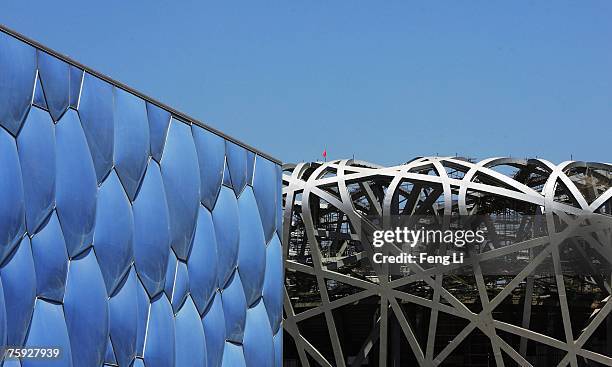 The National Aquatics Center, known as the water cube, stands next to the Beijing National Stadium, known as the bird's nest, on July 10, 2007 in...