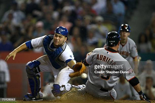 Rich Aurilia of the San Francisco Giants slides home safely as the ball gets past catcher Russell Martin of the Los Angeles Dodgers in the fifth...