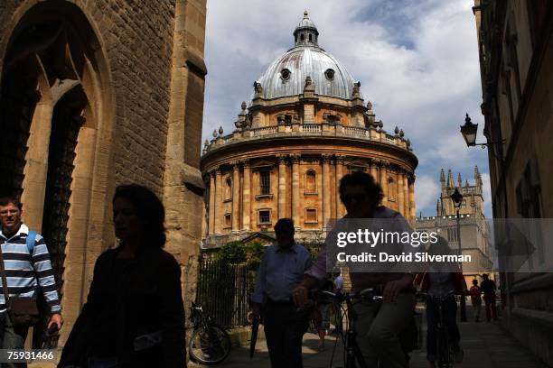 People pass the Radcliffe Camera, an 18th century Oxford University building housing reading rooms of the Bodleian Library, on August 1, 2007 in...