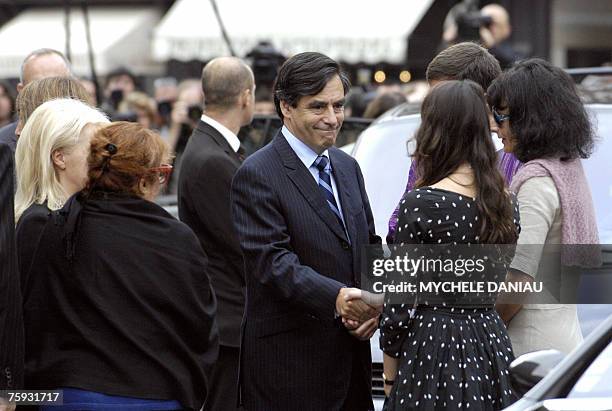 French Prime Minister Francois Fillon comforts Nathalie Serrault and Gwendoline Courreges , daughter and grand-daughter of French actor Michel...