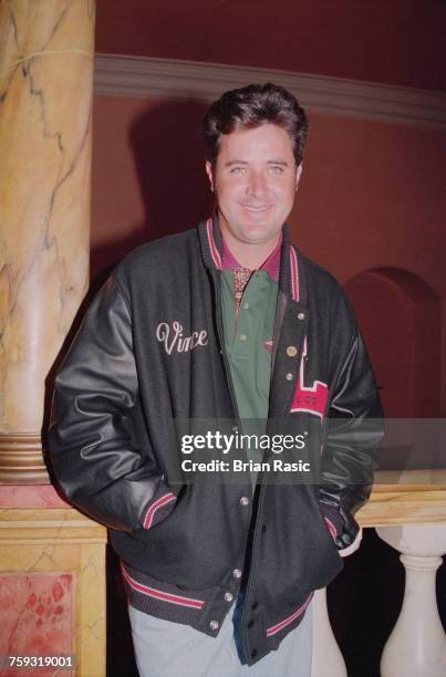 American country singer and musician, Vince Gill posed wearing a personalised varsity team jacket at the Royal Albert Hall in London in May 1994.