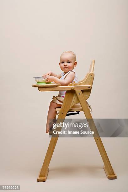 baby in a high chair - baby eating food imagens e fotografias de stock