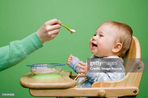 adult feeding baby - mother baby food stock pictures, royalty-free photos & images