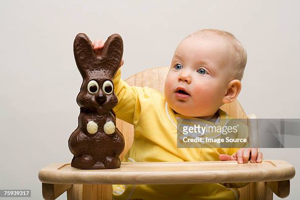 baby with chocolate bunny - baby bunny stock pictures, royalty-free photos & images