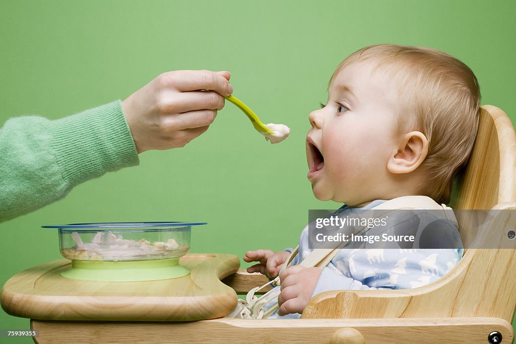 Adult feeding baby