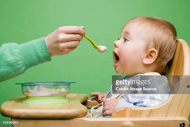 adult feeding baby - mother baby food stock pictures, royalty-free photos & images