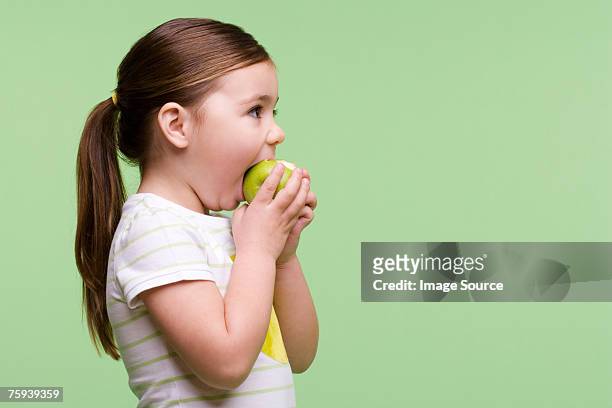 girl eating an apple - apple bite out stock pictures, royalty-free photos & images