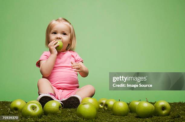 chica comiendo una manzana - one baby girl only fotograf�ías e imágenes de stock