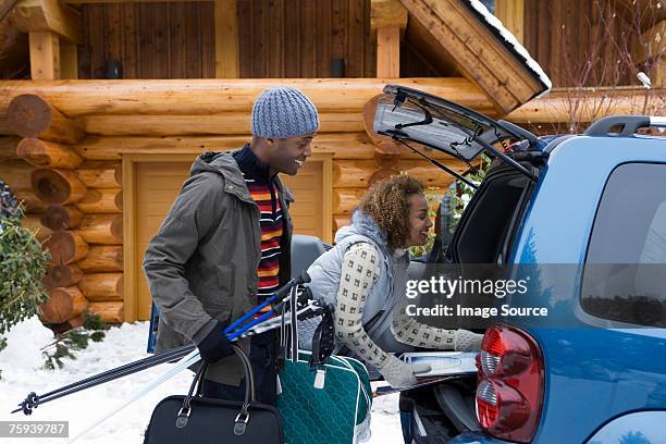 couple packing car boot - holiday packing stockfoto's en -beelden