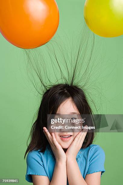 girl with hair sticking to balloons - static electricity stock pictures, royalty-free photos & images