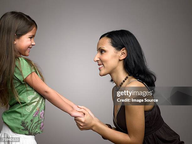 mutter hält tochter hände - man and woman holding hands profile stock-fotos und bilder