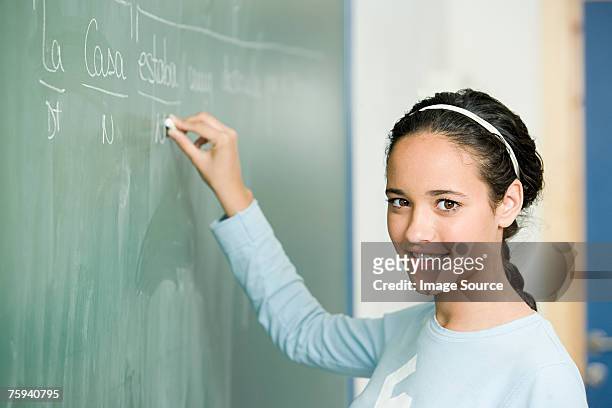 girl writing on blackboard - spanish and portuguese ethnicity stock pictures, royalty-free photos & images