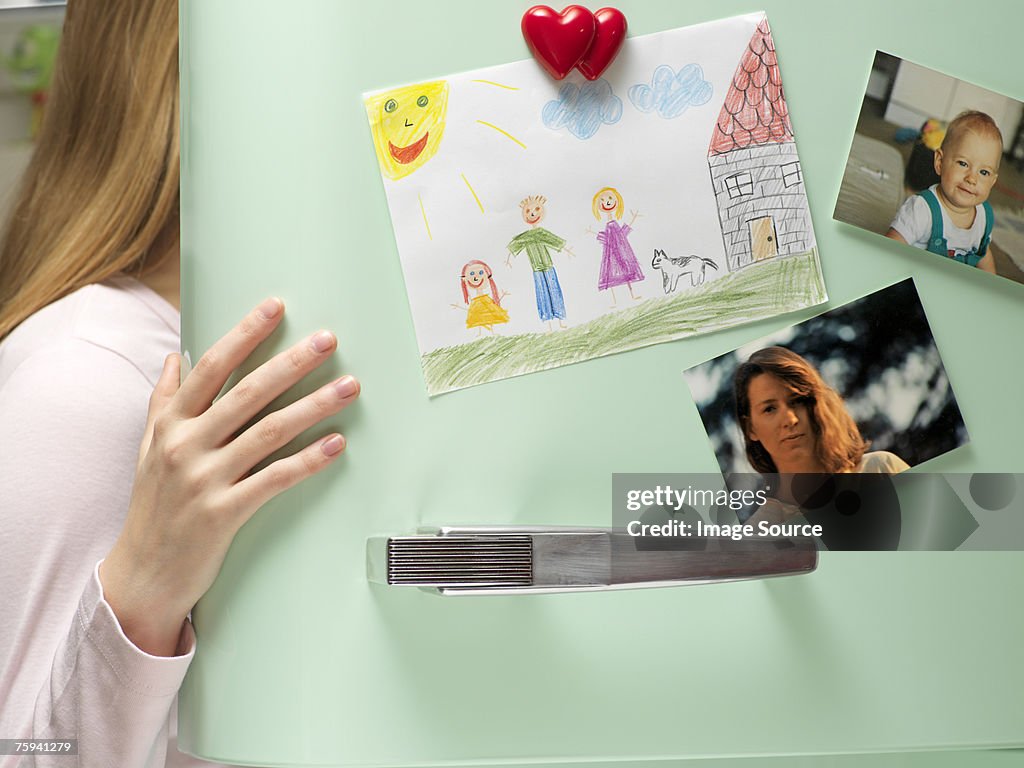 Photographs and drawing on refrigerator door