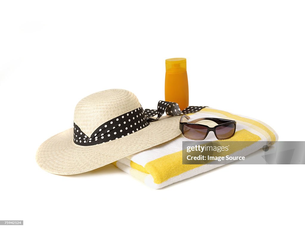 Sunglasses beach towel sunhat and suncream