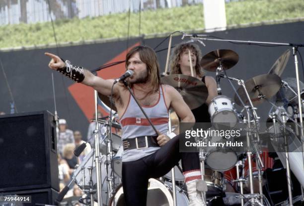 Singer Bruce Dickinson of the metal band "Iron Maiden" points to the crowd as the drummer Clive Burr plays behind him at The Oakland Coliseum in...