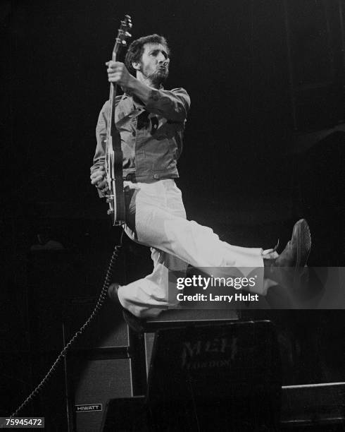 Guitarist Pete Townshend of the rock and roll band "The Who" leaps as he plays his electric guitar while performing onstage in circa 1978.