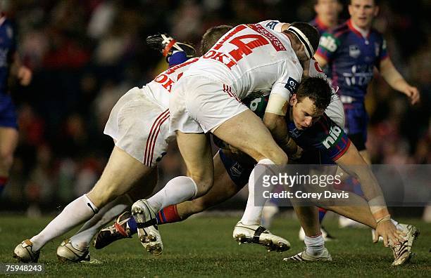 Josh Perry of the Knights is tackled by Dragons defence during the round 21 NRL match between the Newcastle Knights and the St George Illawarra...