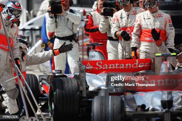 Fernando Alonso of Spain sits in front of Lewis Hamilton of Great Britain and McLaren Mercedes in the pits during the Hungarian Formula One Grand...