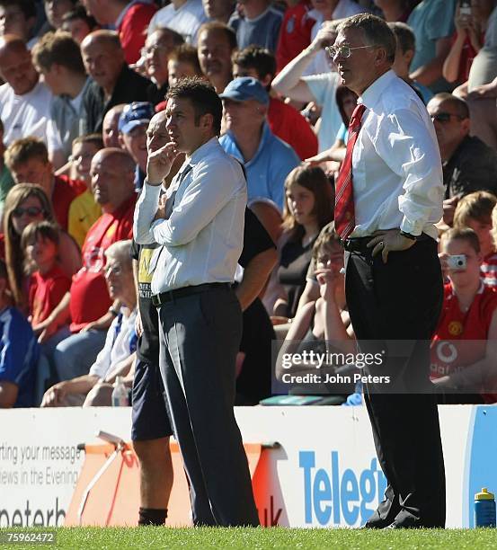 Darren Ferguson of Peterborough United and Sir Alex Ferguson of Manchester United watch from the touchline during the pre-season friendly match...