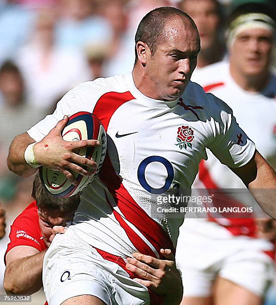 England's scrum-half Shaun Perry is tackled by Wales's prop Iestyn Thomas during their friendly rugby union match against England at Twickenham in...