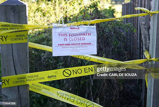 Sign preventing people from using a public footpath warns of the risk of foot and mouth disease infection near a farm area in Wanborough, Surrey,...