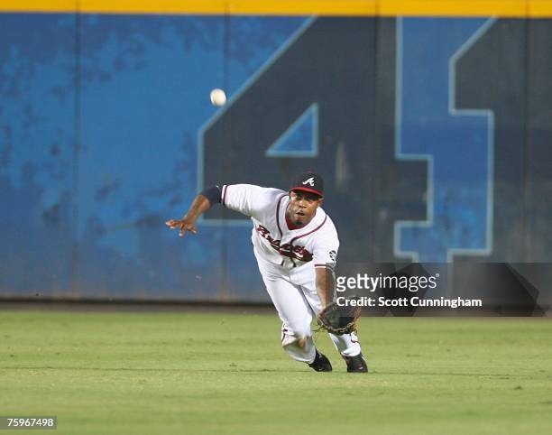 Willie Harris of the Atlanta Braves makes a diving catch against the Colorado Rockies at Turner Field August 4, 2007 in Atlanta, Georgia. The Braves...