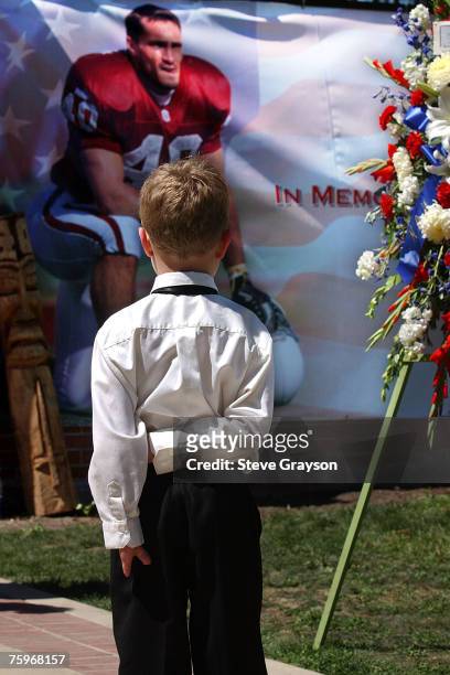 Young boy stops to view a poster of Pat Tillman, the former NFL player who joined the Army Rangers and was killed in action in the Middle East.