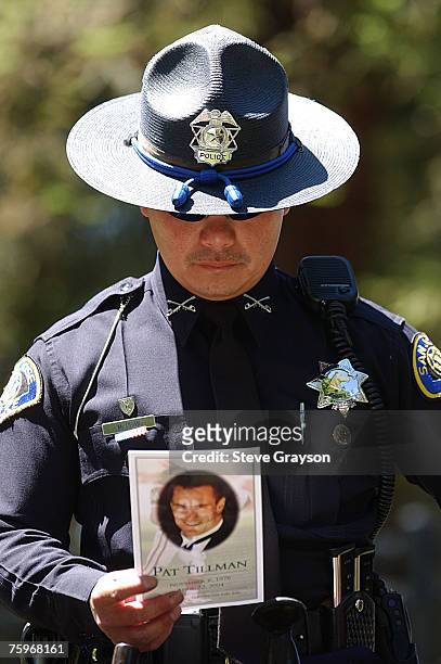 Member of the San Jose Police Department reads from the program of the memorial services for Pat Tillman at the San Jose Municipal Rose Garden May 3,...